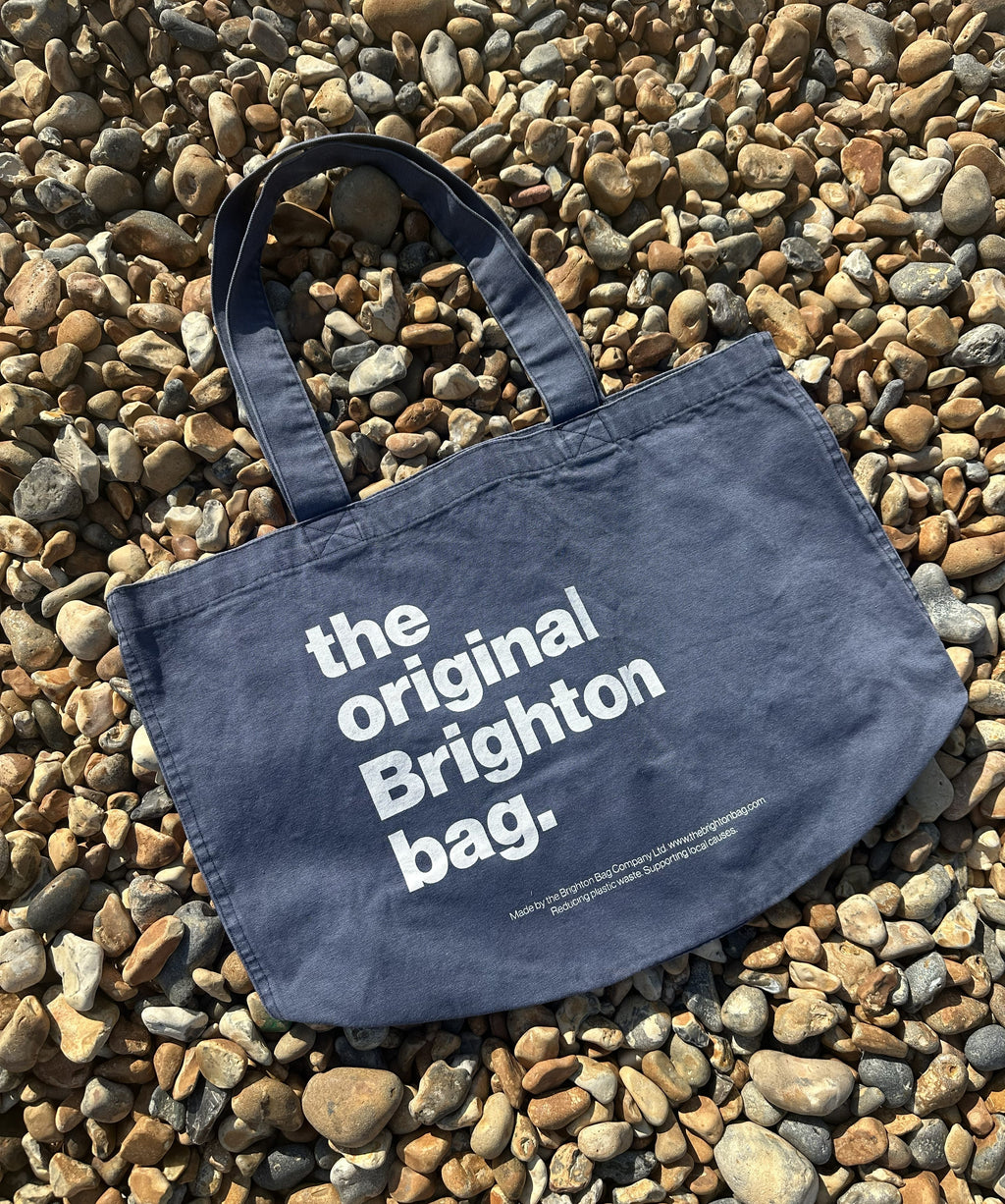 Navy tote bag with 'the original Brighton bag' text on pebbles